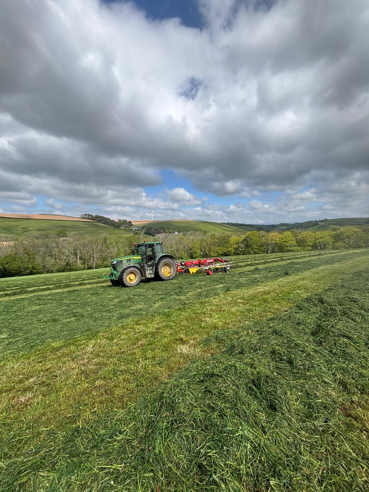 Tractor mowing — rolling countryside